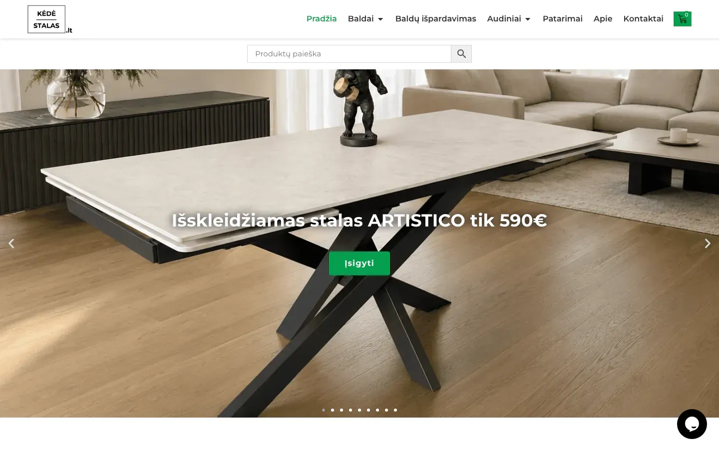 Kėdė Stalas online furniture store homepage with a product search bar and a slider showing an extendable dining table in a modern living room with a green buy button