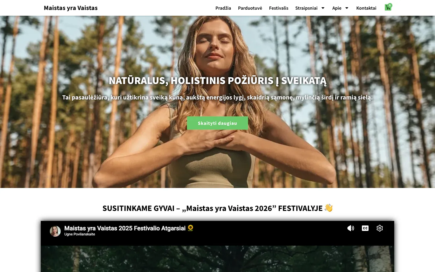 Maistas yra Vaistas homepage with a woman breathing calmly in a pine forest, the heading Natūralus, holistinis požiūris į sveikatą (a natural, holistic approach to health) and a festival video below